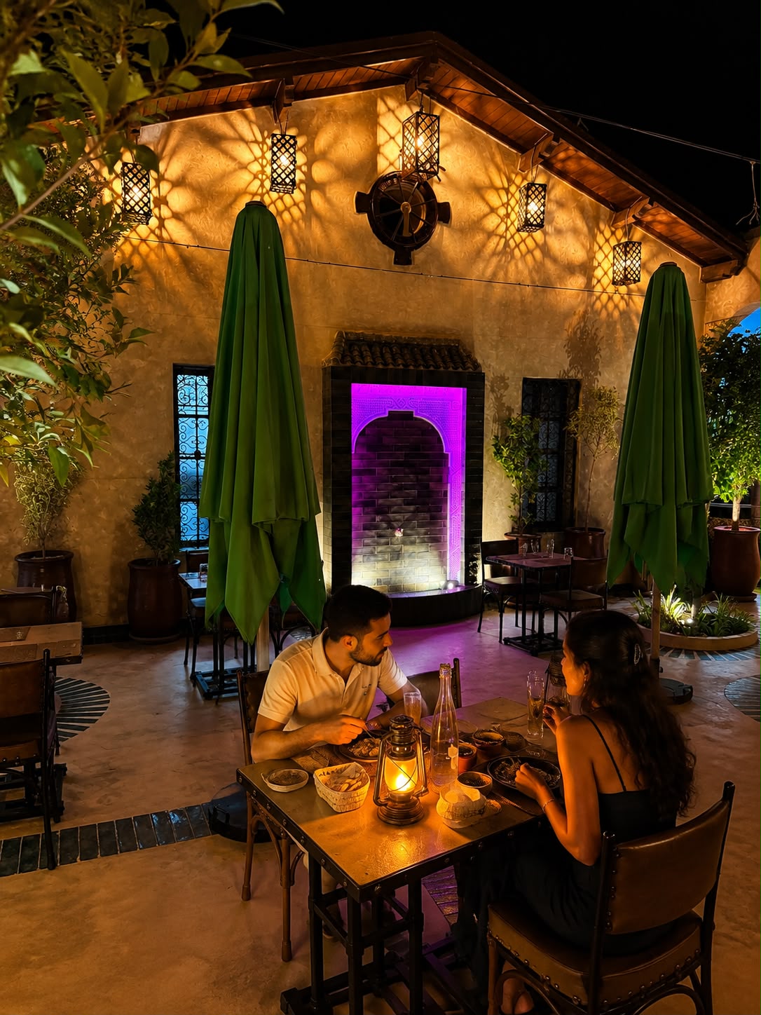 Couple dînant le soir près de l'arche illuminée du patio